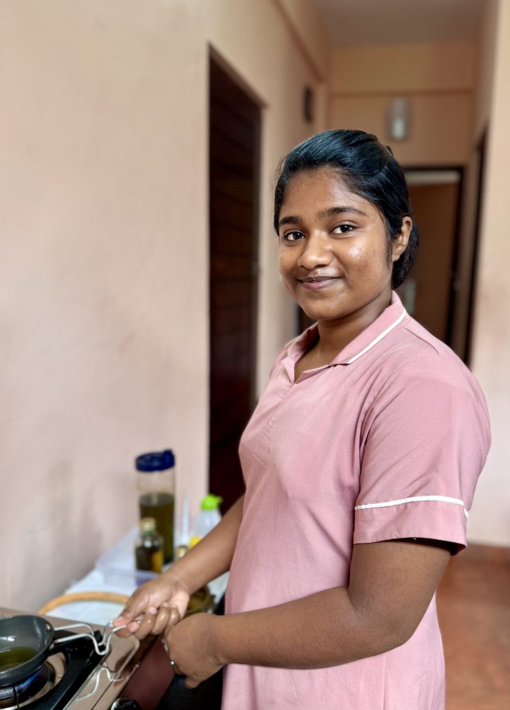Josmy - Massage Therapist at Prakruthi Ayurveda, Cherai Beach, warming an Ayurvedic oil
